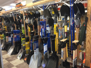 A wall of various tools hanging on hooks.