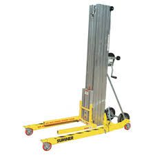 A yellow lift with wheels and a metal pole.