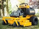 A yellow and black lawn mower sitting in the grass.